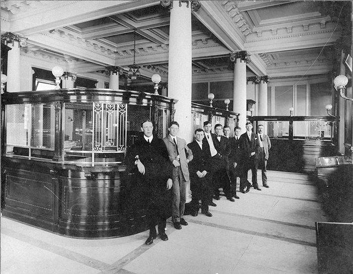 Interior view of the Merchants Bank of Canada, circa 1906, showing banking details.